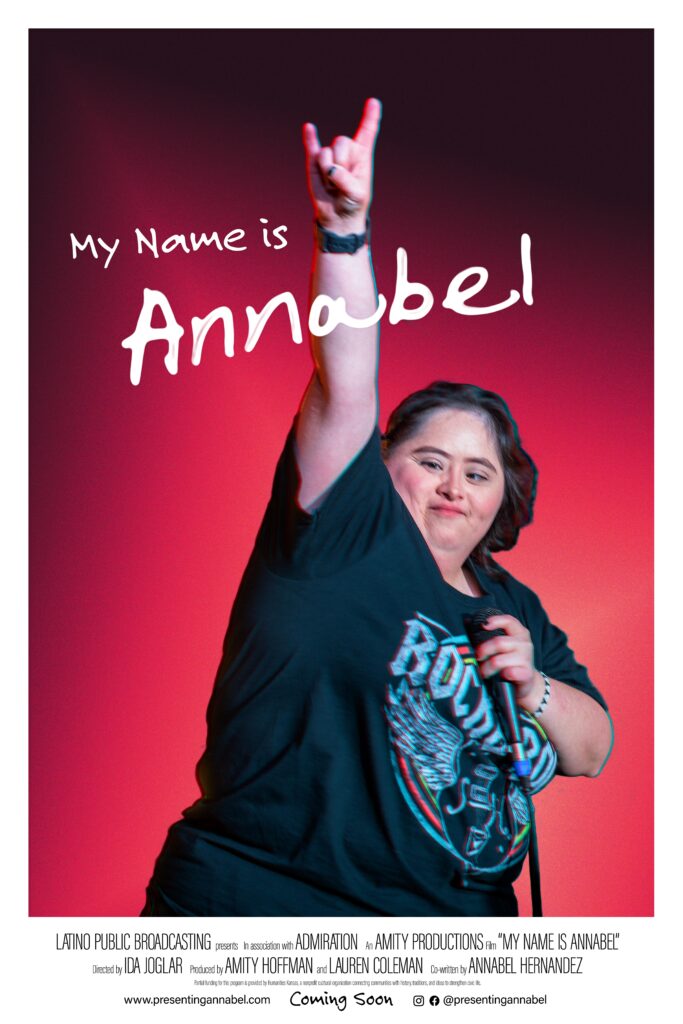 Film poster for My Name Is Annabel. On the poster is a picture of Annabel with a microphone in her hand. She is wearing a black rock and roll t-shirt , and her hand is raised in the air in triumph. Behind her is a red background. At the top is the title of the film.